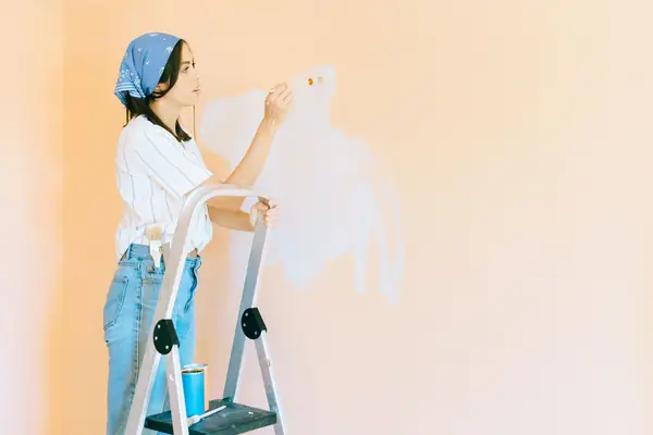 Interior painting in Springfield: painter on a stepladder rolling a wall